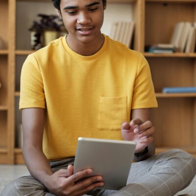 Boy in Yellow Crew Neck T-shirt and Gray Pants Sitting on Carpet
